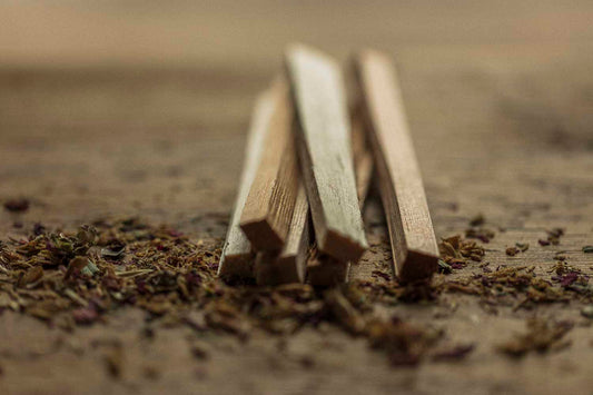 Wooden sticks on a textured surface with dried herbs