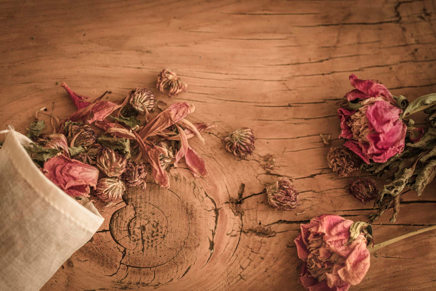 Herbal yoni steam blend with dried peonies, clover, and botanicals spilling from a cotton pouch on rustic wood background – Peony for Your Yoni by Wylde Gold