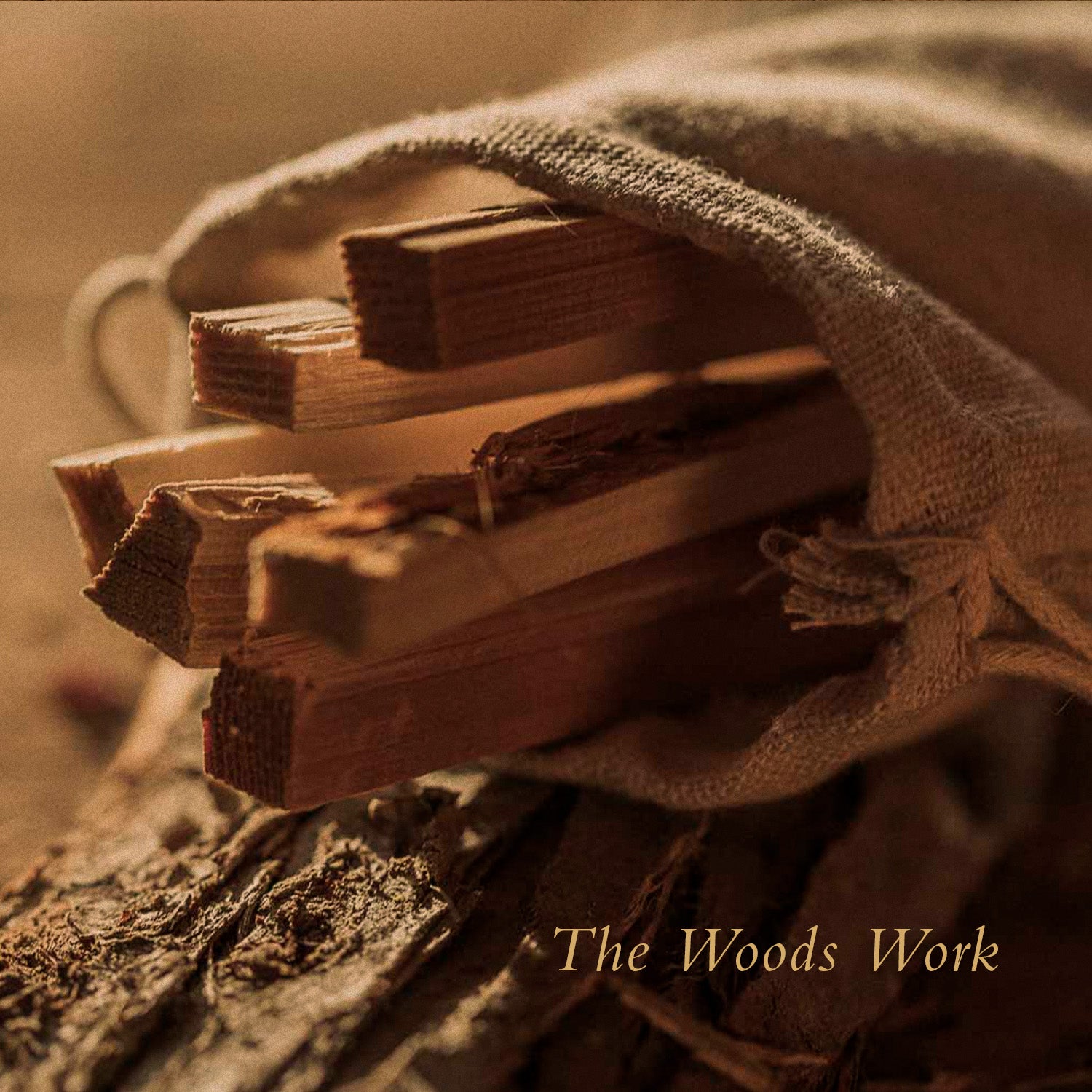 Cedar sticks in a burlap drawstring bag perched on bark. The Woods Work.