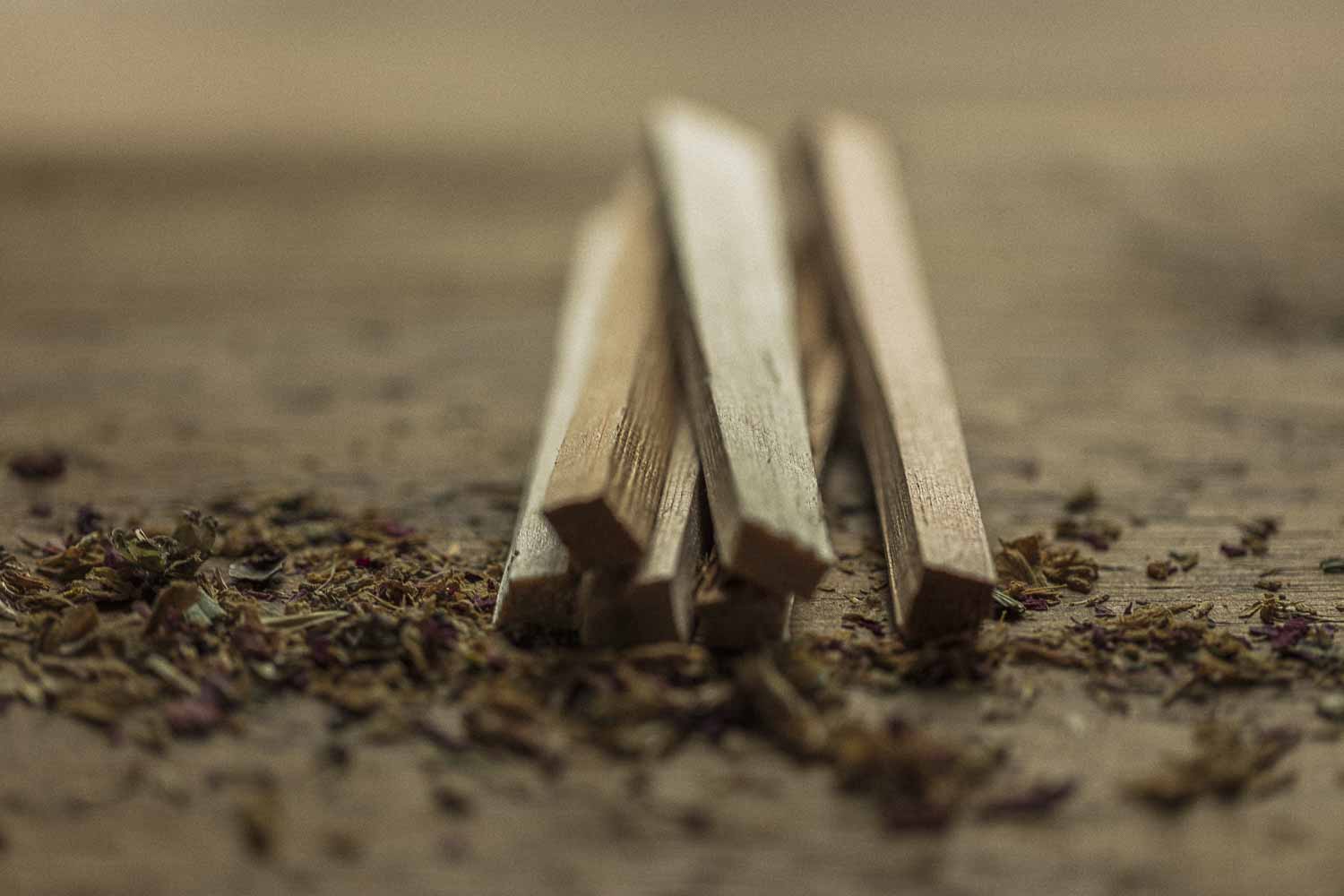 Wooden sticks on a textured surface with dried herbs