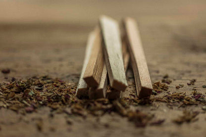 Wooden sticks on a textured surface with dried herbs