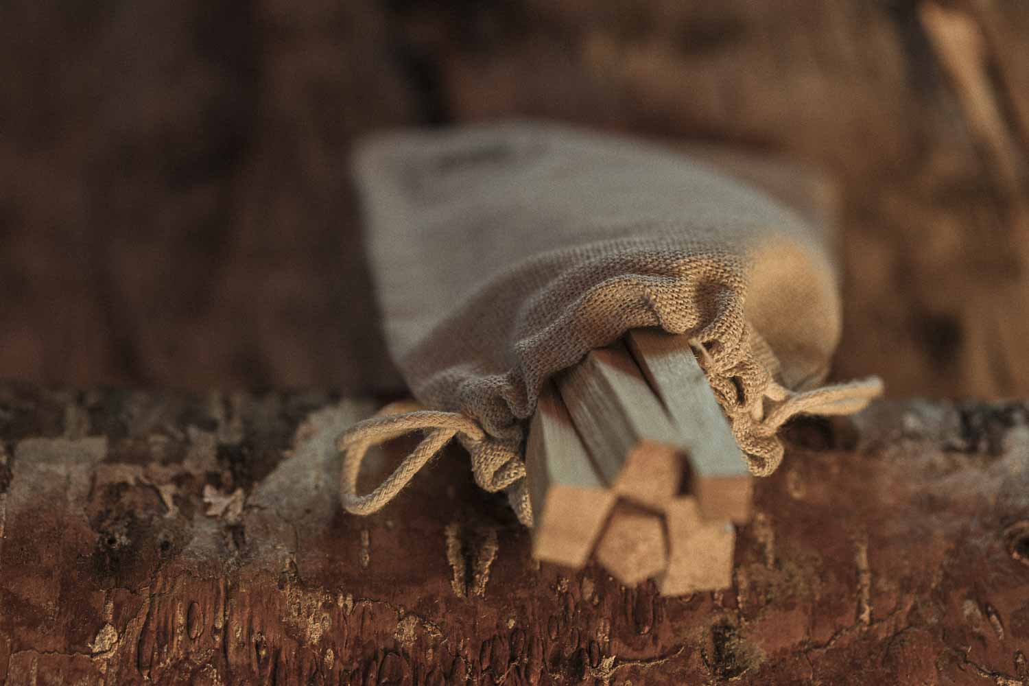 Small wooden tool or set of tools wrapped in cloth on a wooden surface