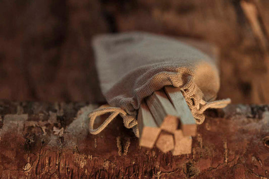 Small wooden tool or set of tools wrapped in cloth on a wooden surface