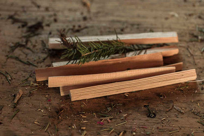 Wooden smudge ritual sticks with a small branch on a wooden surface