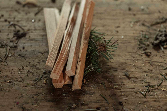 Wooden smudge ritual  sticks and a small pine branch on a wooden surface