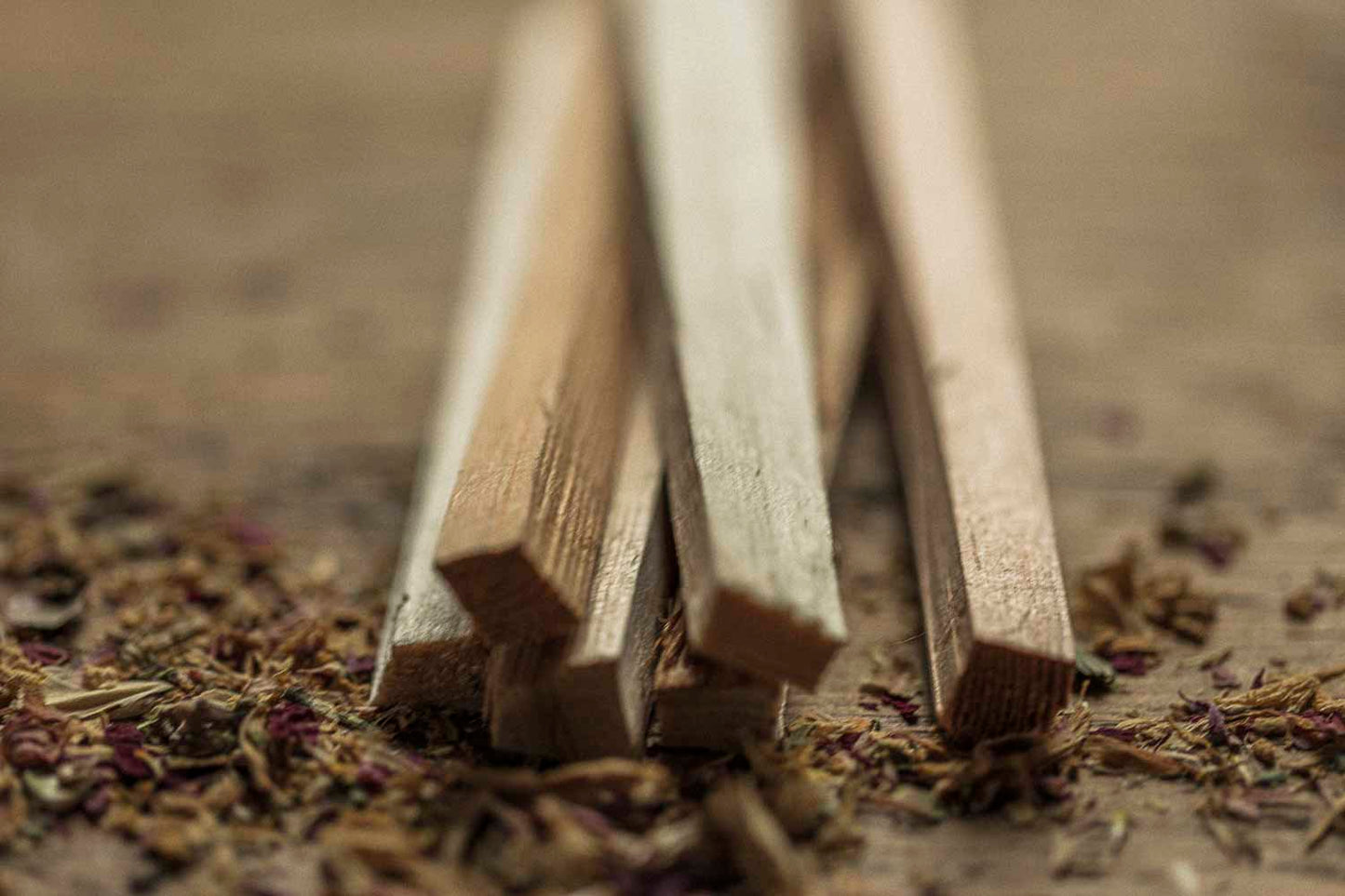 Wooden sticks on a textured surface with dried herbs