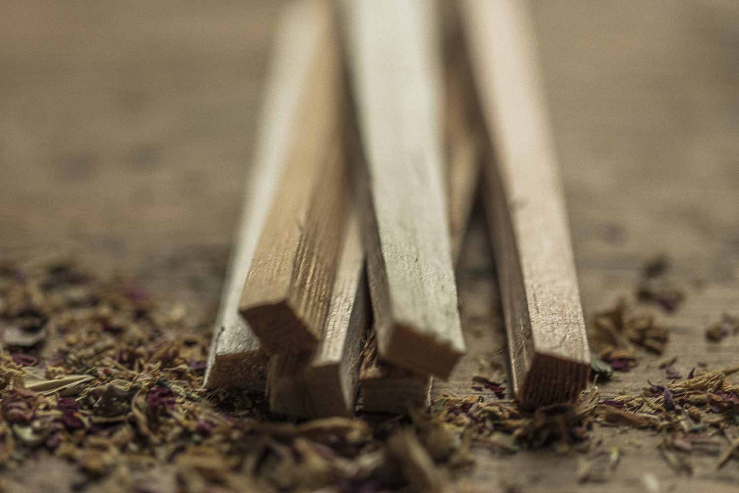 Wooden sticks on a textured surface with dried herbs