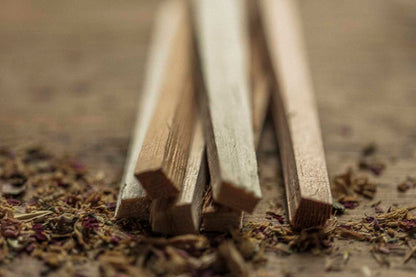 Wooden sticks on a textured surface with dried herbs