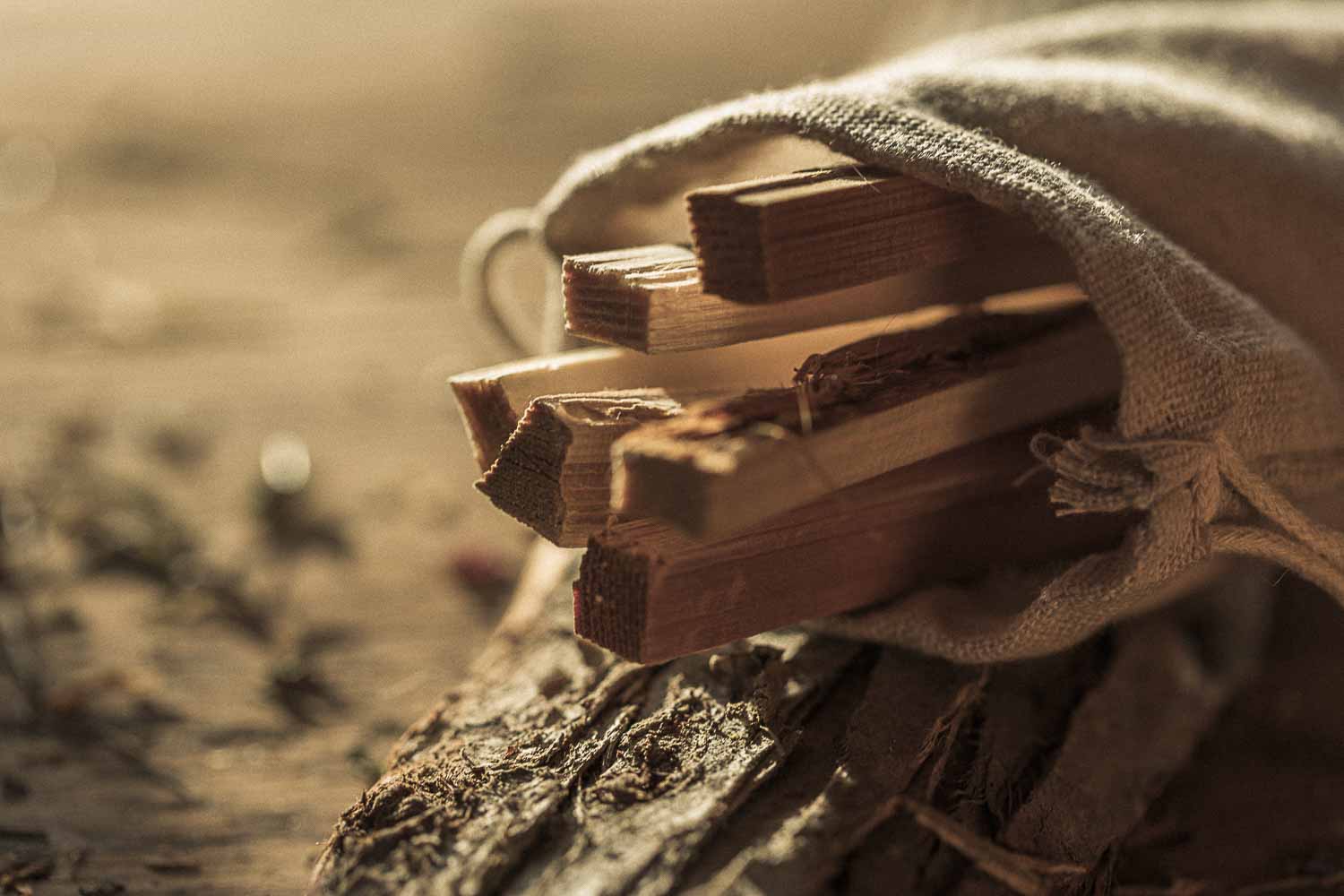 Wooden sticks held by a drawstring bag in a natural setting