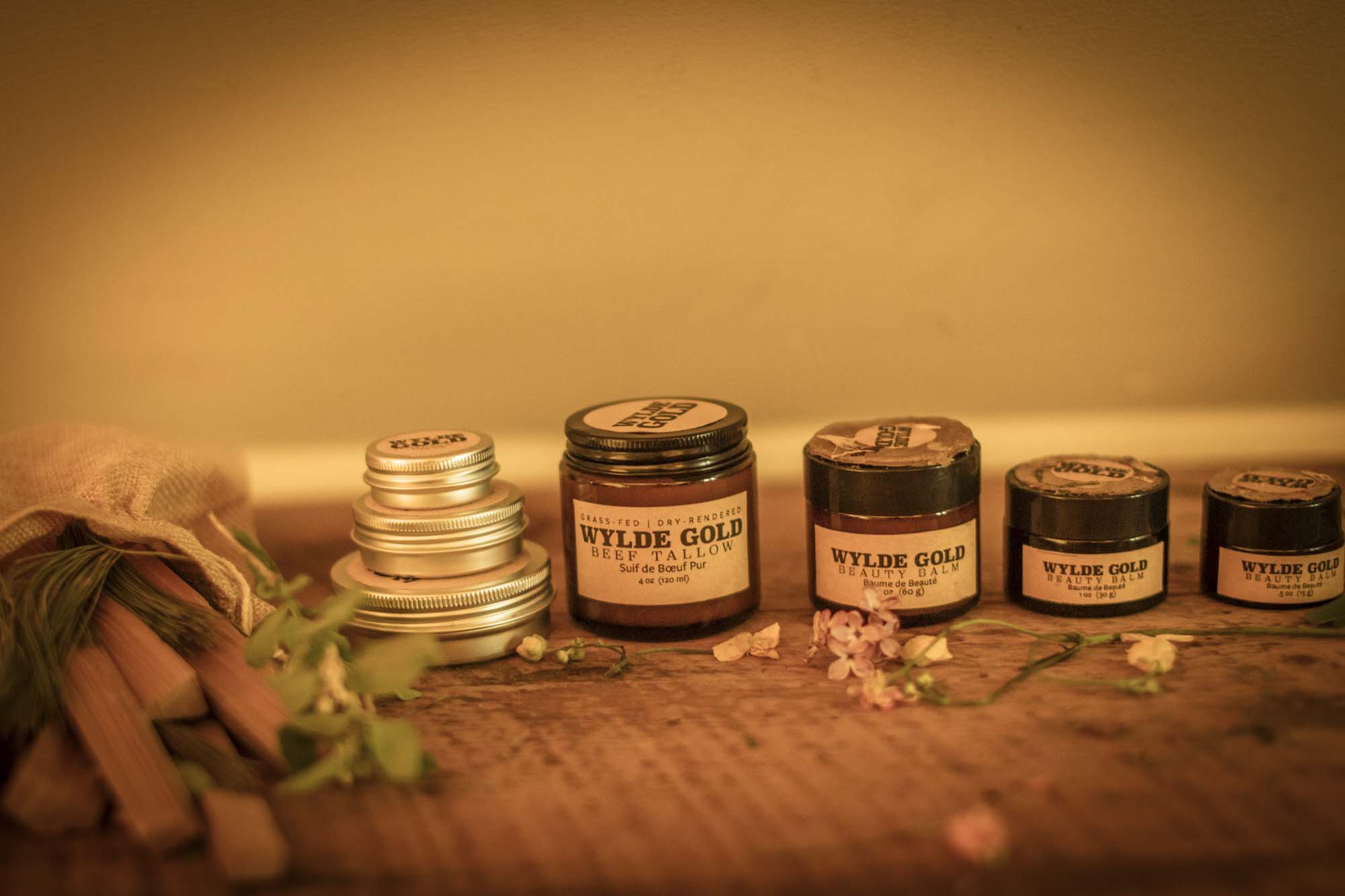 WYLDE GOLD ritual shelf — warm-toned balm collection and herbal display  on rustic wood 