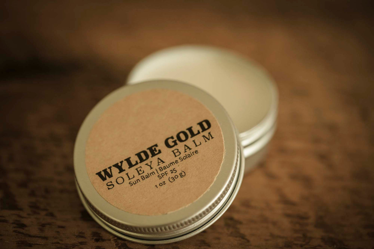 WYLDE GOLD Soleya Balm —  grass-fed tallow sun shield ritual in an open tin on rustic wood