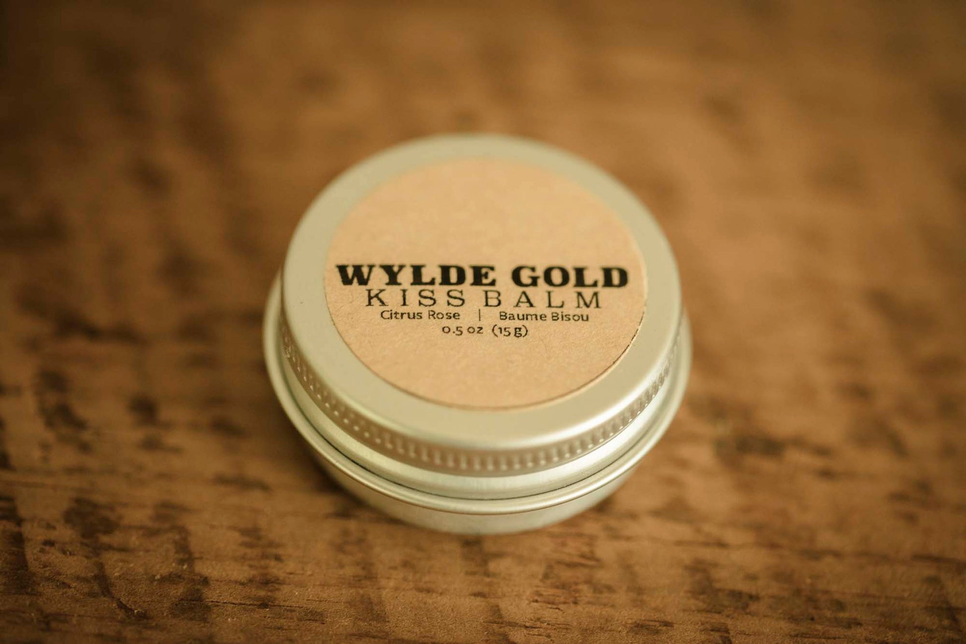 WYLDE GOLD Kiss Balm — Citrus Rose scented grass-fed tallow lip ritual in a tin on wood