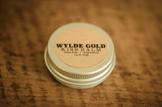 WYLDE GOLD Kiss Balm — Citrus Rose scented grass-fed tallow lip ritual in a tin on wood
