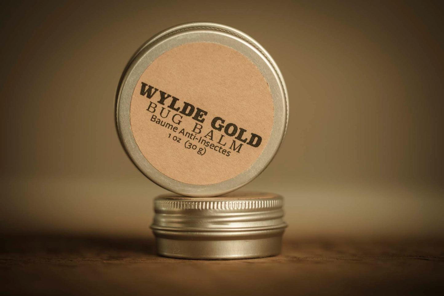 WYLDE GOLD Bug Balm —  grass-fed tallow bug repellent balm in a tin on rustic wood