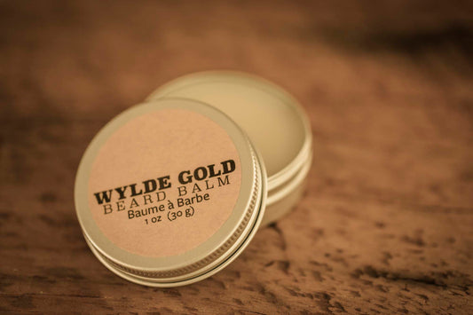 WYLDE GOLD Beard Balm —  grass-fed tallow balm in an open tin on rustic wood