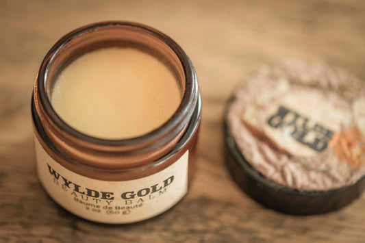 An open jar of molten-gold balm, smooth as moonlit butter, waiting to melt into skin.