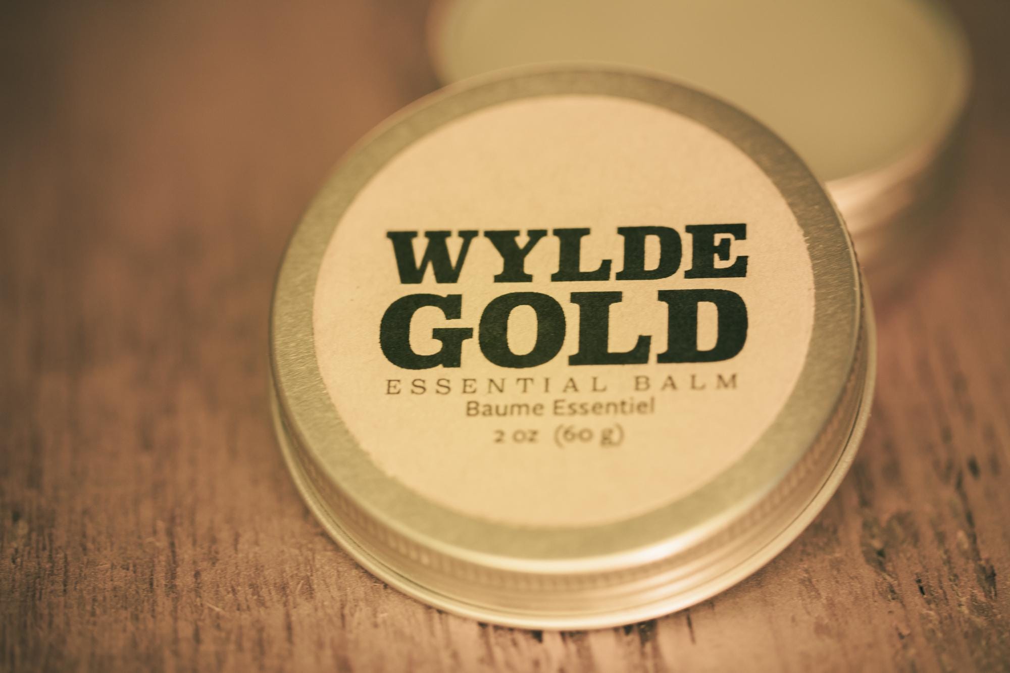 WYLDE GOLD Essential Balm —  grass-fed tallow balm in a tin on rustic wood